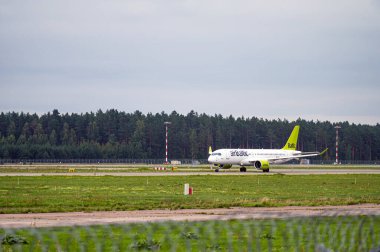 Riga, Letonya - 31 Ağustos 2021: AirBaltic Airbus A220-300 YL-AAS bulutlu bir sonbahar gününde RIX Uluslararası Havaalanından havalandı