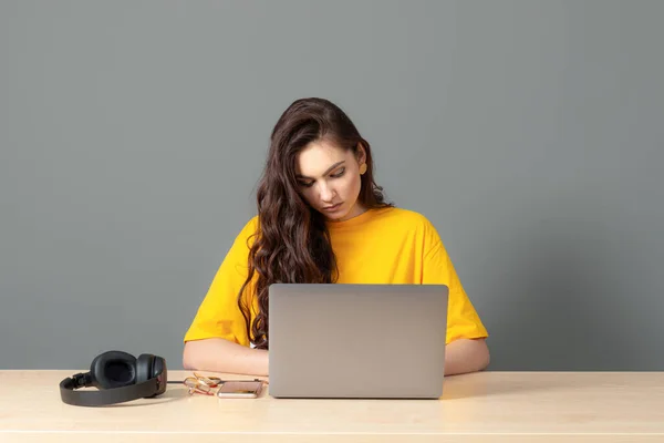 坐在桌旁的年轻女性 在工作时使用现代技术 在线工作概念 — 图库照片