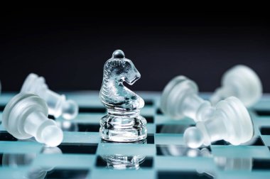 glass chess board game in black background ,selective focus on King, leadership ,winner concept