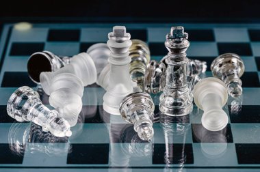glass chess board game in black background ,selective focus on King, leadership ,winner concept