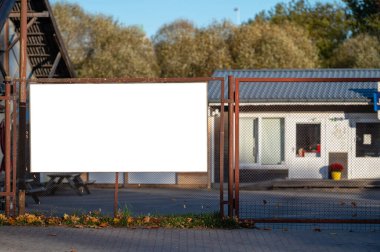 Metal çitlerin üzerinde boş beyaz reklam afişi