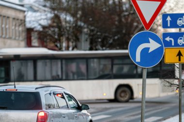 Kışın şehirde arabalar yolda ilerler. Trafik işaretleri, trafik ışıkları ve araçla birlikte trafiğe bak
