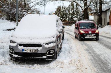 Dobele, Letonya - 13 Aralık 2022: Taze karla kaplı araçlar sokağa park edildi