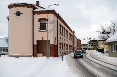 Dobele, Letonya - 13 Aralık 2022: Soğuk bir kış günü Skolas Caddesi 'nde müzik okulu inşaatı ve trafik.