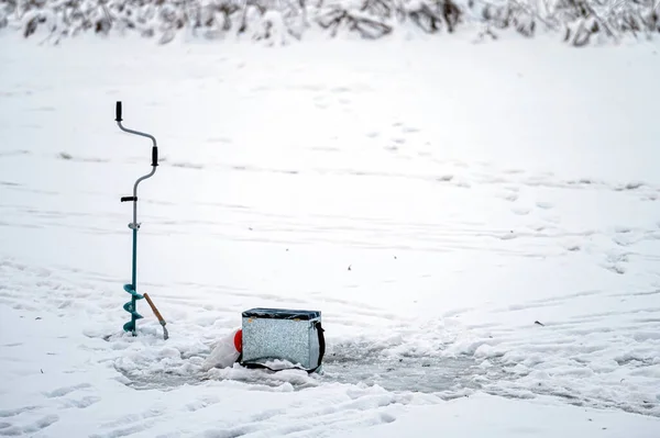 Fishing equipment for winter ice fishing on the background of a frozen river. Ice fishing.