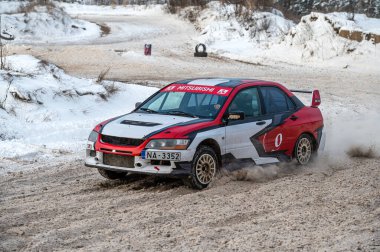 Tukums, Latvia - January. 7. 2023: Youngsters practice safe driving on a winter track with the Mitsubishi Lancer Evo street sports car