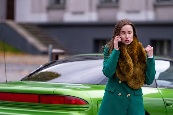 Uma Mulher Falando Telefone Enquanto Estava Perto Carro Verde Estacionado — Fotografia de Stock