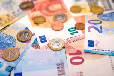 background of banknotes and euro coins of different denominations close-up