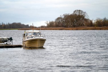 Nehir kıyısına yanaşmış küçük bir yat.