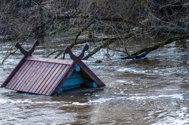 Bahar sellerinde taşan bir kuş evinin çatısına. Letonya, Dobele 'deki Berze Nehri' nde bir besleyici.