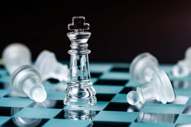 glass chess board game in black background ,selective focus on King, leadership ,winner concept
