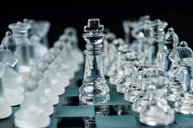 Transparent glass chess pieces on dark background. Leadership ,confrontation and  strategy concept