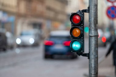Trafik ışıklarıyla şehir trafiğini bulanık görmek, ön planda yeşil ışığı olan bir semafor.