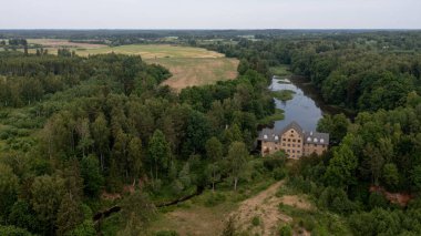 Katrina su değirmeninin antik binası. Gölün yanında, Krimulda, Letonya.