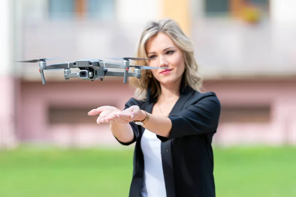 drone landing on hands of young blonde woman, modern technology concept