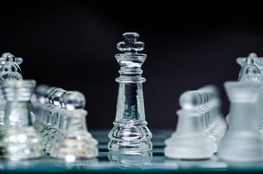 Transparent glass chess pieces on dark background. Leadership ,confrontation and  strategy concept