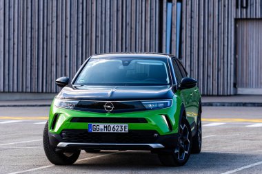 Riga, Letonya - 26 Mart 2021: yeşil elektrikli araç Opel Mokka-e halka açık otoparkta, geleceğin teknolojileri, modern tasarım