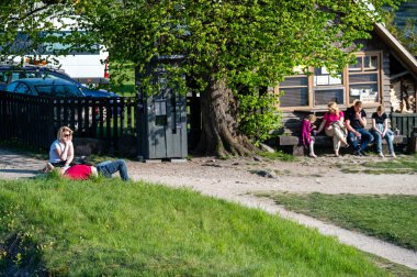 Engure, Letonya - 13 Mayıs 2023: Turistler Avrupa 'nın en geniş şelalesi olan Ventas Rumba yakınlarındaki bir dinlenme bölgesinde dinleniyor.