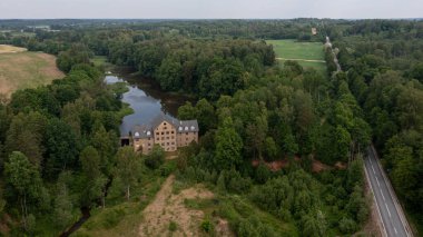 Katrina su değirmeninin antik binası. Gölün yanında, Krimulda, Letonya.