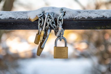 Traditional locks of lovers on the bridge across the river in winter. Symbol of love and fidelity