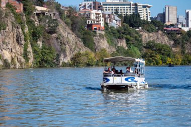 Tiflis, Gürcistan - 8 Ekim 2023: Turistler Mtkvari, Kura Nehri boyunca bir zevk gemisine biniyorlar.