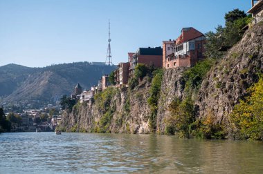 Tiflis, Gürcistan - 8 Ekim 2023: Turistler Mtkvari, Kura Nehri boyunca bir zevk gemisine biniyorlar.