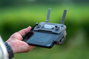 İHA 'nın uzaktan kumandasını elinde tutan bir adamın yakın çekimi, seçici odaklanma