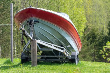 Yeşil bir çayırda nakliye karavanındaki bir motorlu tekne.