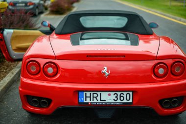 Riga, Letonya - 21 Haziran 2015: Kırmızı Ferrari 360 Spider hediye servisi kiralık araba süpermarket otoparkında, arka manzara