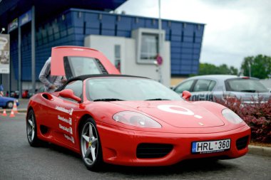 Riga, Letonya - 21 Haziran 2015: Kırmızı Ferrari 360 Spider hediye servisi kiralık arabası süpermarketin otoparkında