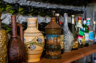 Litene, Letonya - 25 Mayıs. 2023: Kilerdeki rafta farklı alkollü içecek şişeleri koleksiyonu.