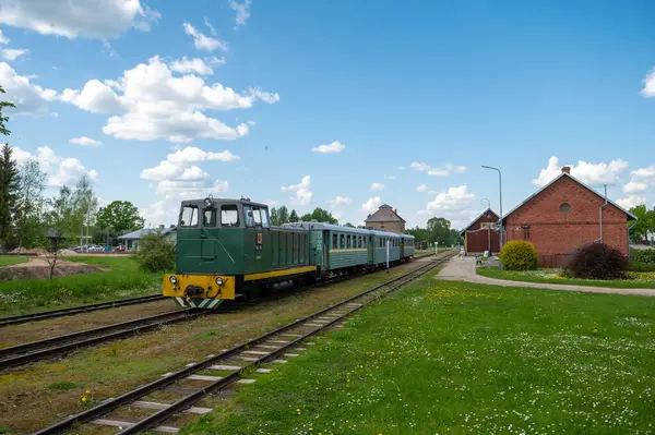 stock image Aluksne, Latvia - May 24. 2023: Aluksne train station with narrow gauge train in front.