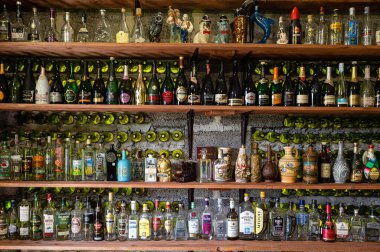 Litene, Letonya - 25 Mayıs. 2023: Kilerdeki rafta farklı alkollü içecek şişeleri koleksiyonu.