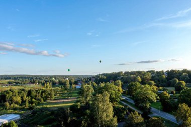 Sıcak hava balonları sahada uçuyor. Mavi gökyüzünde renkli sıcak hava balonları. Kandava, Letonya