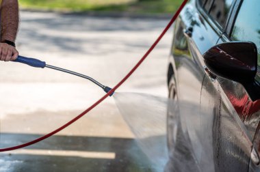 Yüksek basınçlı araba yıkama sprey tabancası ile yakın plan araba yıkama.