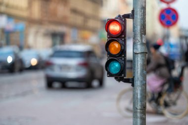 Bulanık arka planda semaforlu bir şehir. Akşam caddelerinde arabalar, kırmızı ışık.