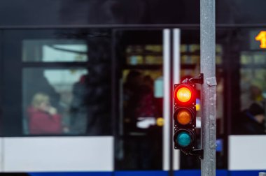 Trafik ışıklarıyla şehir trafiğinin bulanık görüntüsü, ön planda kırmızı ışıklı bir semafor.