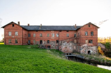 Bene, Letonya 'da nehir kıyısındaki bir köyde eski bir kırmızı tuğla fabrikası.