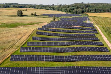 Çimenli bir yamaca kurulmuş büyük bir güneş çiftliği.