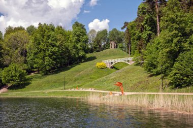 Letonya 'nın Aluksne kasabasındaki Temple Hill parkında granit kubbe ve tahta yaya köprüsü.