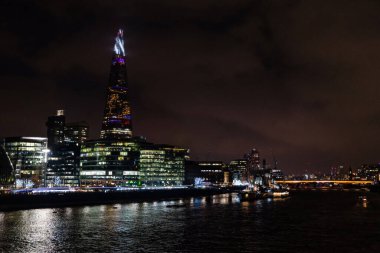 Londra, İngiltere, İngiltere - 31 Aralık 2019: Çömlek Thames Nehri 'nin yanında geceleyin aydınlanıyor.