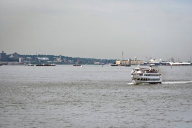 New York, ABD - 7 Haziran 2019: Arka planda Manhattan silueti olan bir feribot Hudson Nehri 'nden geçiyor.