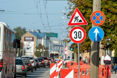 Riga, Letonya - 30 Eylül 2020: Sonbaharda işlek bir şehir yolu boyunca araçlar yol inşaatında yol almaktadır.