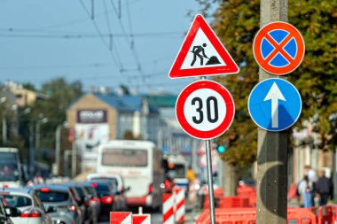 Riga, Letonya - 30 Eylül 2020: Sonbaharda işlek bir şehir yolu boyunca araçlar yol inşaatında yol almaktadır.