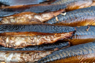Taze tütsülenmiş balıklar canlı bir pazarda sergileniyor, zengin aromalı müşterileri cezbediyor..