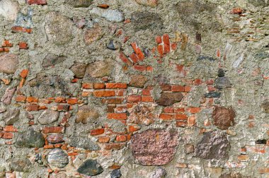 Duvarda taşlardan ve tuğlalardan oluşan bir karışım sergileniyor. Tarihi önemi vurgulanıyor..