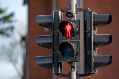 Kırmızı yaya sinyali yandı, tuğla bir binanın yanında durduğunu gösteriyor..