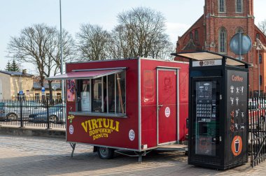 Liepaja, Letonya - 19 Mart 2023: Canlı bir gıda kamyonu gün ışığında bir kahve büfesinin yanına park edildi.