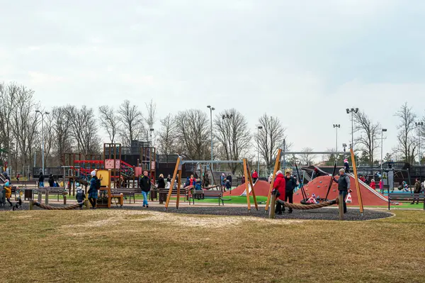Liepaja, Letonya - 19 Mart 2023: Aileler bir bahar öğleden sonrasında bir halk parkında oynamak ve sosyalleşmek için toplandılar.