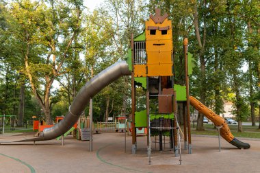 Çocuklar ağaçlarla çevrili slaytlarla ve tırmanma alanlarıyla hareketli bir oyun alanını keşfedebilirler..